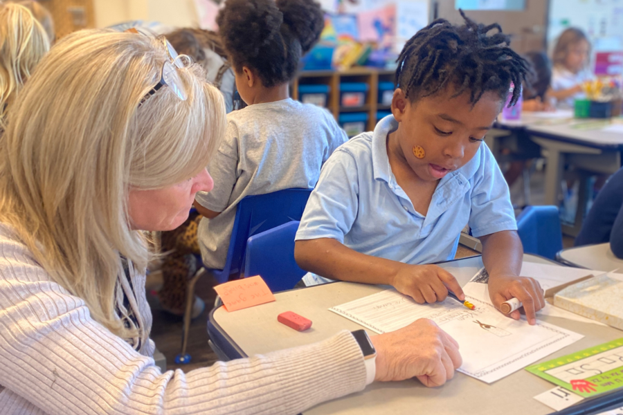 a teacher helps a first grade student at St. Elizabeth's School