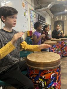 a middle school boys on a tubano drum in music class at St. Elizabeth's Denver