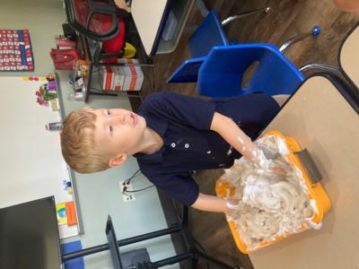 a young boy plays with shaving cream to learn about mass at St. Elizabeth's School