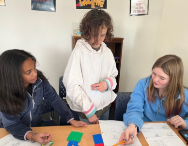Three middle schoolers work on a math problem at St. Elizabeth's School