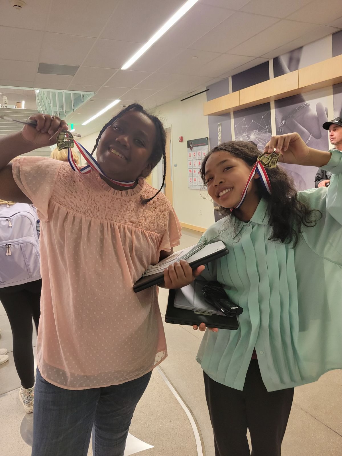 Two girls from St. Elizabeth's School show off their medals from Speech and Debate