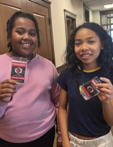 Two girls from St. Elizabeth's School show off their newspaper club press passes