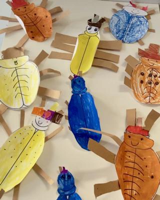 a photo of students' work, bugs cut out of different paper parts