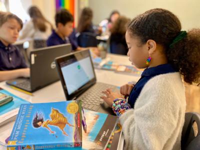 a fifth grade girl types on a computer at St. Elizabeth's School