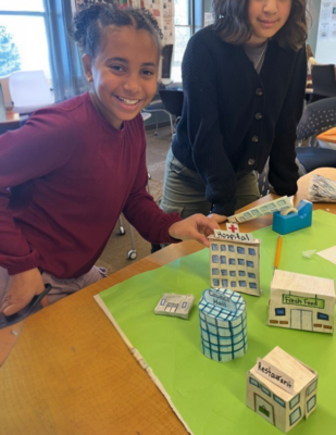 a girl shows off her city built in 6th grade social studies