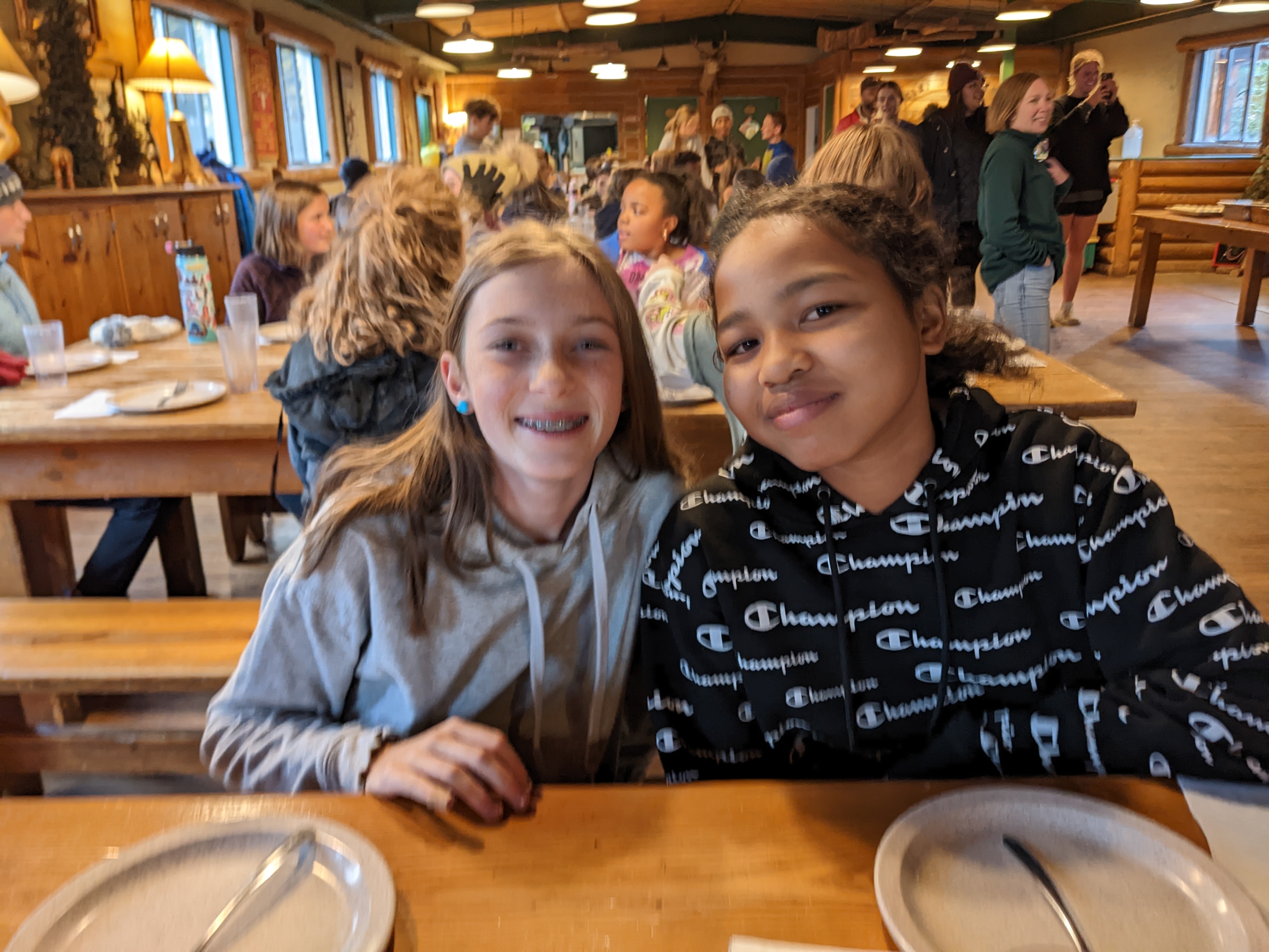 Two girls smiling at the camera at meal time