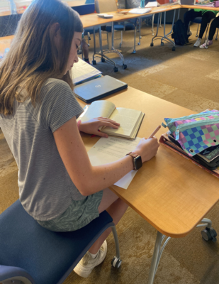 a girl takes notes out of a passage in a book