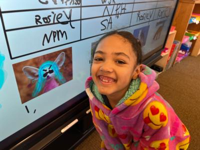 A second grade girl smiles at the camera at St. Elizabeth's School in Denver