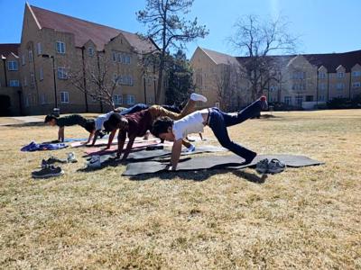 third grade students practice yoga on the green at St. Elizabeth's School in Denver